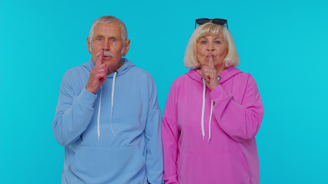 Elderly Couple in Blue and Pink Hoodies