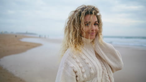 Mujer-Posando-En-La-Playa-De-Otoño-Con-Un-Suéter-Cálido.-Rubia-Despreocupada-Disfrutando-De-La-Orilla-Del-Mar