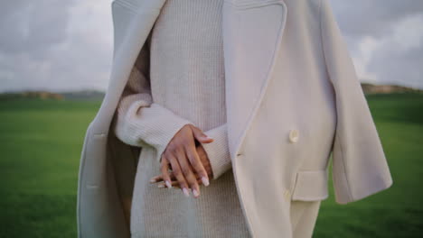 closeup anxious woman hands at green field. nervous girl comforting herself