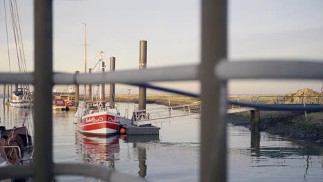 Sailboat-on-reflective-water-in-empty-harbor,-marina-or-port-shot-from-a-bridge-or-landing-stage-on-a-sunny-day-in-Cuxhaven,-northsea,-northern-Germany