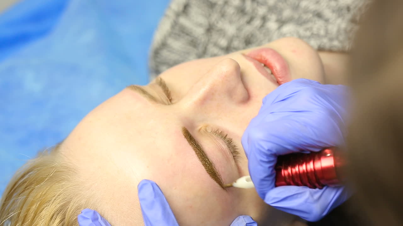 Tattooist using tattoo pen machine for eyebrows permanent make up