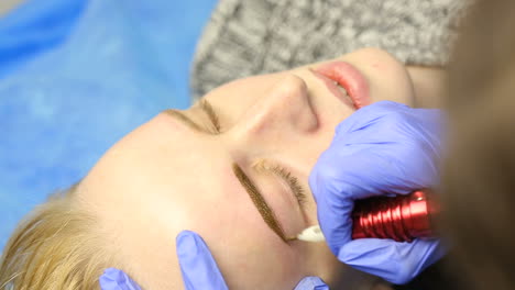 tattooist using tattoo pen machine for eyebrows permanent make up