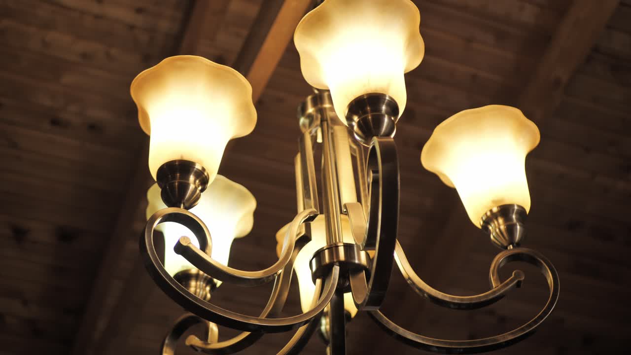 Chandelier In Antique Gold Brass With White Glass Shades. Low Angle Shot