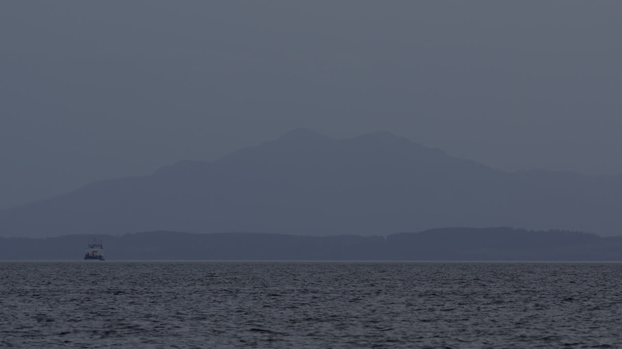 물 위에 보트와 함께 멀리 산과 숲의 꼭대기의 흐릿한 파란 시간 계층 풍경