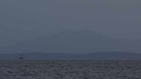 Hora-Azul-Brumosa-Vistas-En-Capas-De-Montañas-Y-Picos-De-Bosques-En-La-Distancia-Con-Un-Barco-En-El-Agua