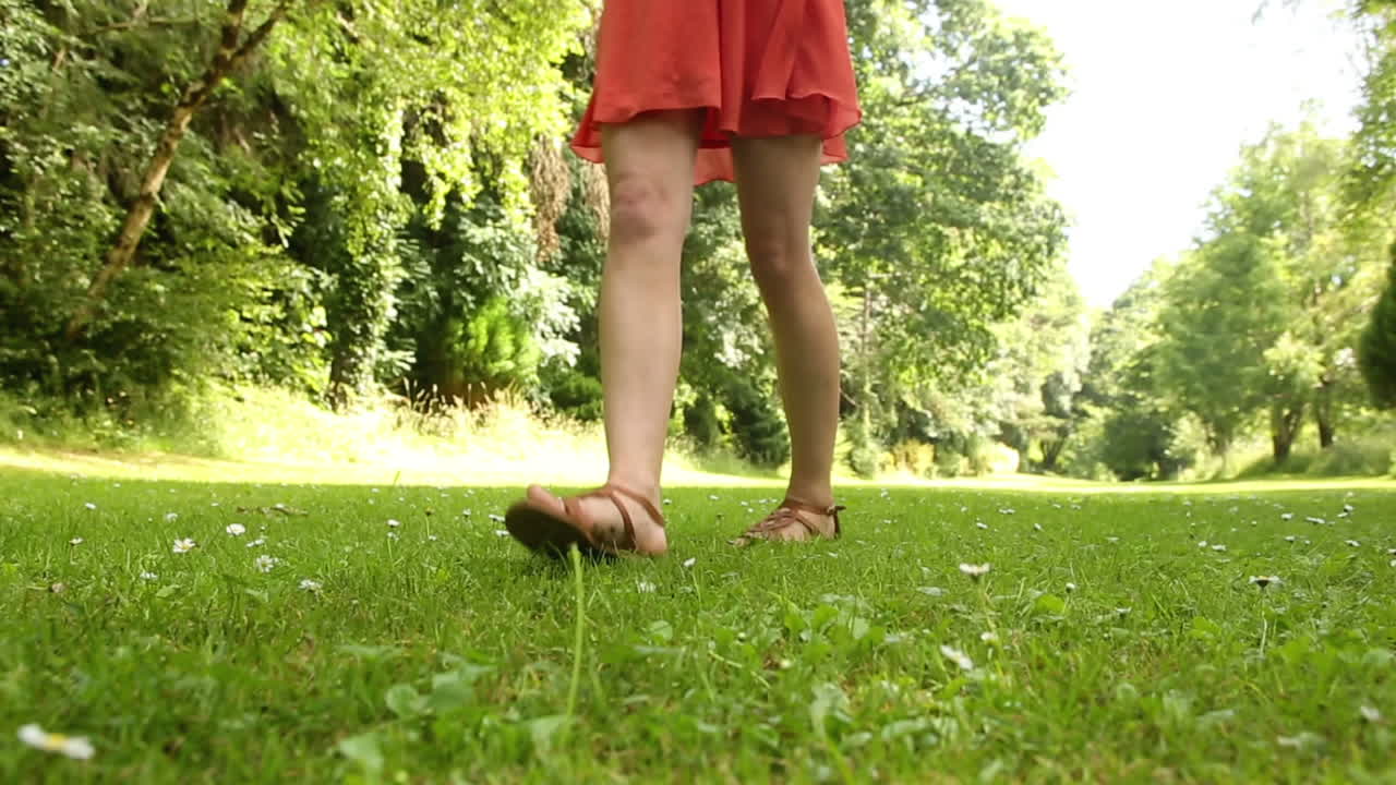 Beautiful teen walking on the grass on a sunny day