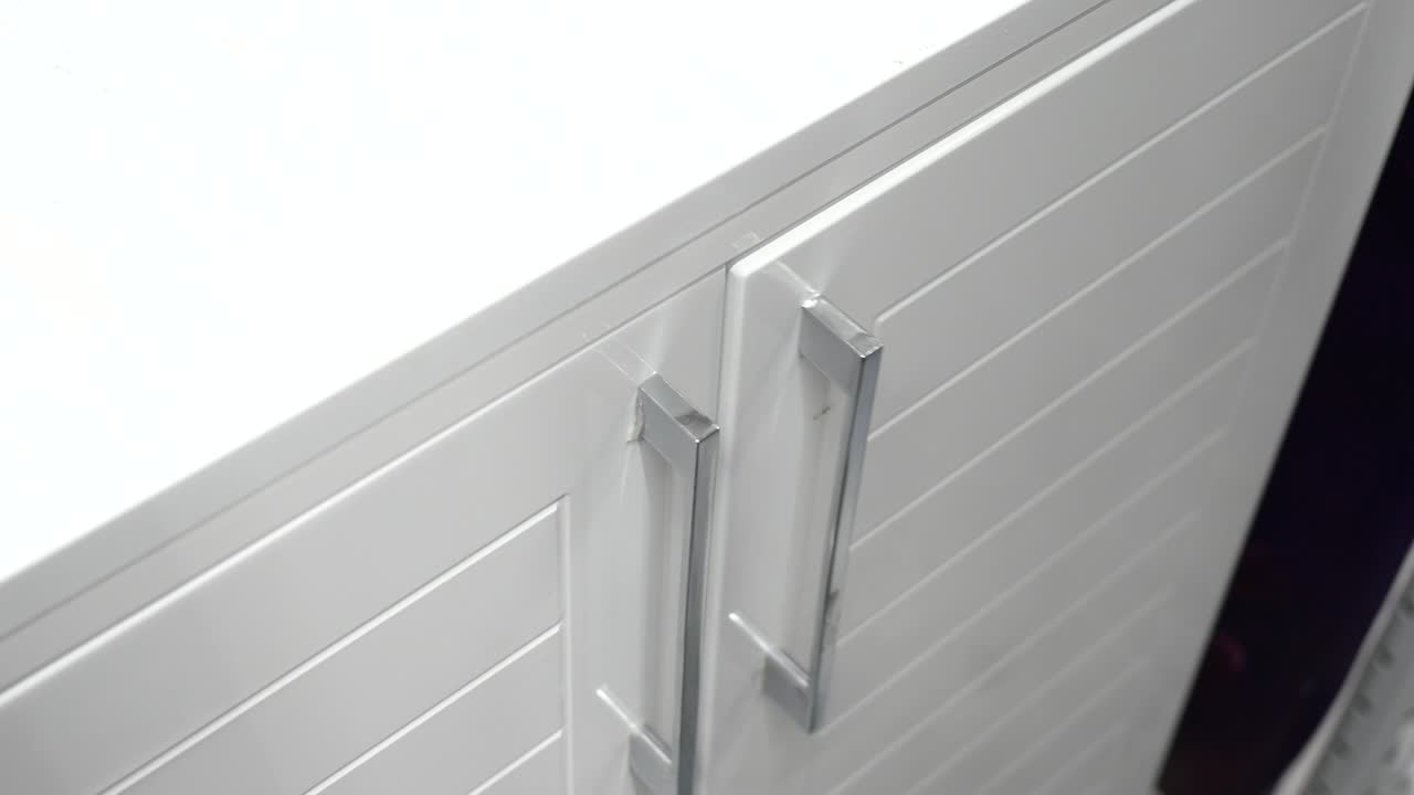 persona abriendo un gabinete moderno blanco