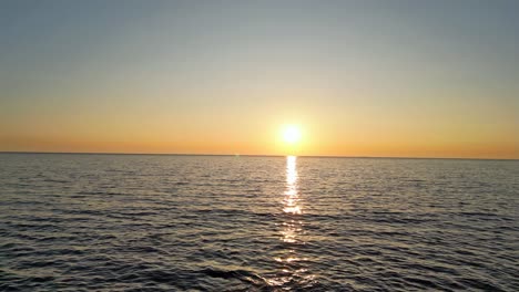 Drone-flight-at-sunset-over-the-sea-in-Tuscany,-Italy:-Golden-sunbeams,-shimmering-sea-and-a-romantic-evening-sky---a-dream-experience-for-photographers-and-nature-enthusiasts