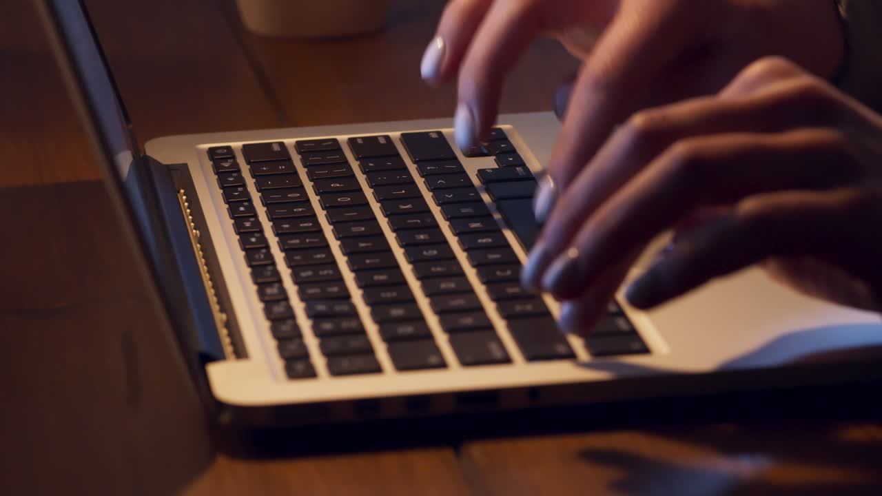 Woman Typing on Laptop Keyboard at Night