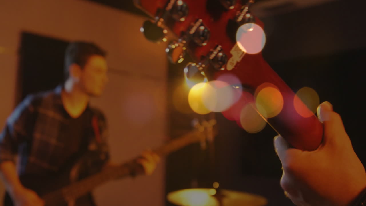 Music industry musicians adjusting guitar tuning pegs on stage, with animated sound wave overlays