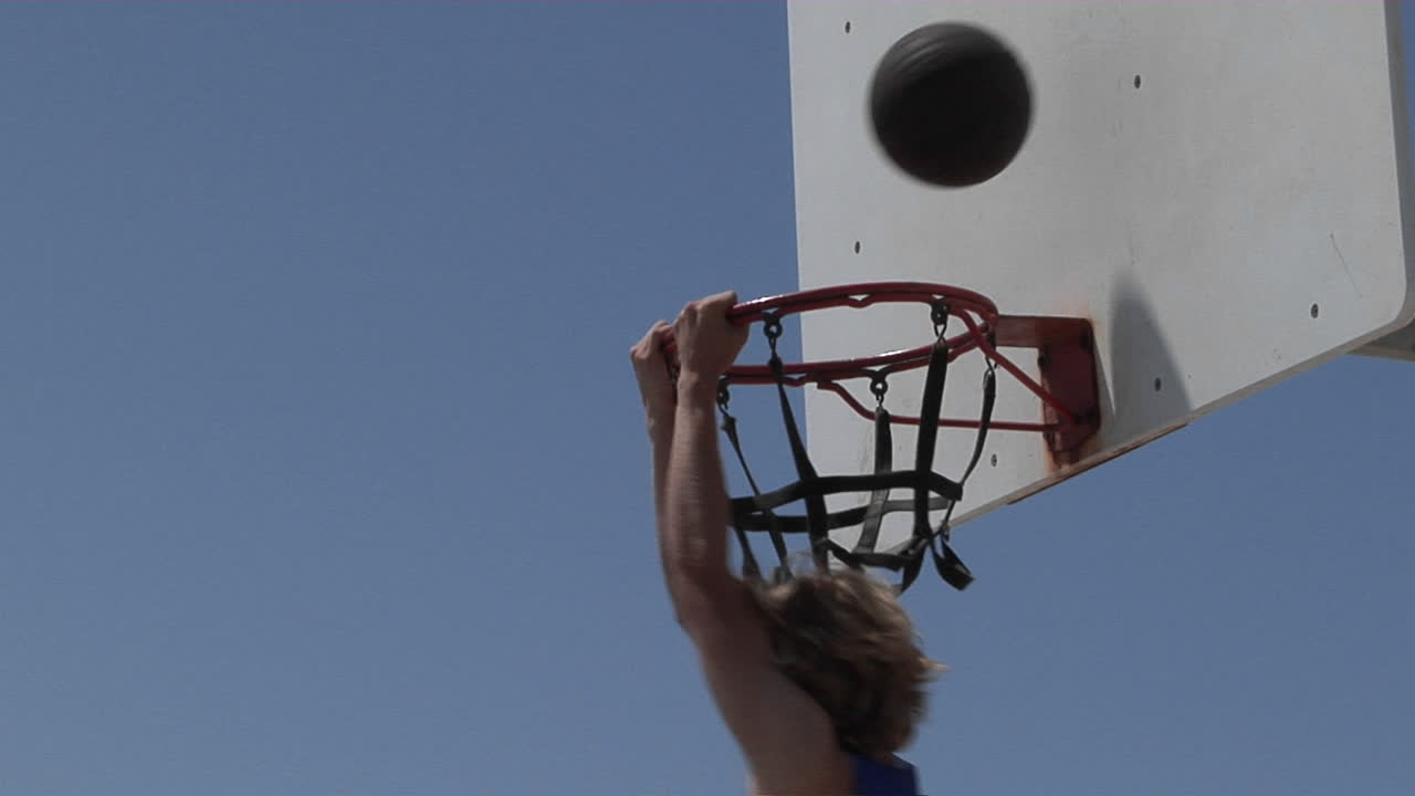 un jugador de baloncesto slam dunks mientras está parado en una escalera de tijera