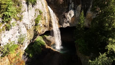 an impressive aerial view captures the dramatic berglistüber waterfall, where water from the fätschbach stream plunges from a high rock face near the klausenpass in glarus süd, switzerland