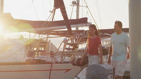 Side-view-of-a-Caucasian-man-and-his-teenage-daughter-walking-harbor-side