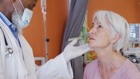 médico afroamericano examinando el cuello de una paciente caucásica en el hospital