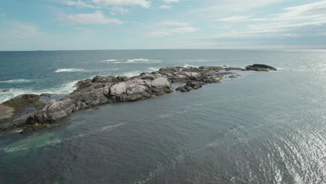 drone footage taking off from the rocky shores of narragansett bay out over the water