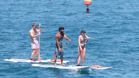 tourists paddle boarding in sorrento, naples, italy