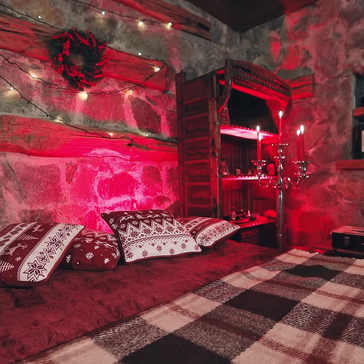 Comfortable bedroom decorated for Christmas. Large bed in cozy room with candlesticks. Romantic background in the house on winter holidays