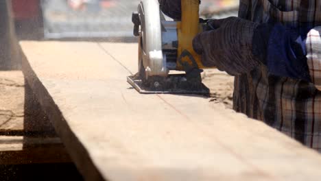 contractor uses a circular had saw to cut and trim wood floor