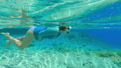 Woman-snorkeling-in-crystal,-clear-waters-of-New-Caledonia---slow-motion-view