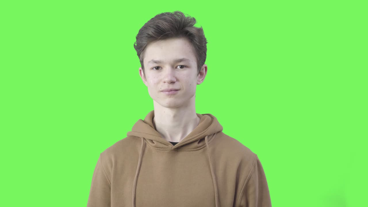 niño mostrando el gesto de esperanza en el fondo chromakey. retrato de morena joven niño caucásico cruzando los dedos. expectativa, ambición, oportunidad, posibilidad. pantalla verde.