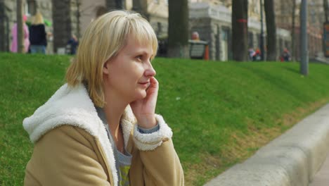 woman resting in the spring park talking on the phone 4k video