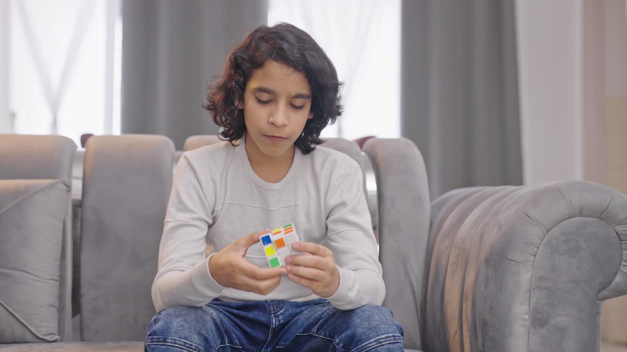 Indian kid boy solving Rubik's cube