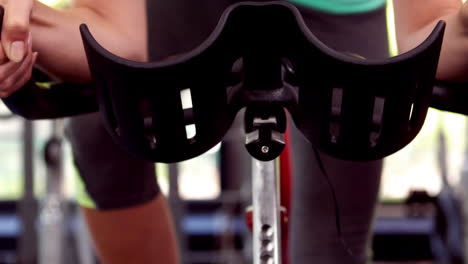 fit woman using exercise bike