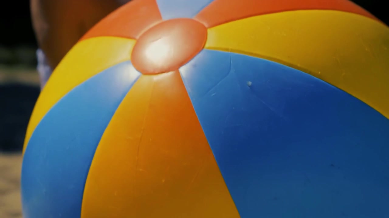 Close-up Bola Pantai Berwarna-warni yang Sedang Dipegang