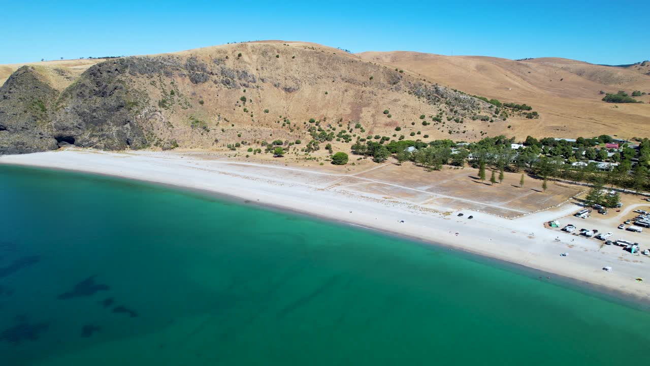 Drone shot moving backwards and curving around to reveal a campsite on Rapid Bay, a popular campsite in South Australia