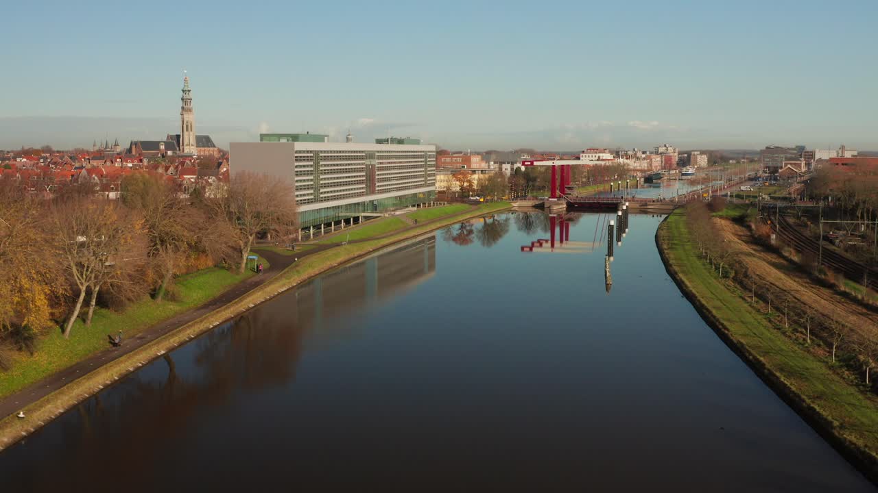 Aerial shot towards a busy bridge next to a train track above a canal in Middelburg