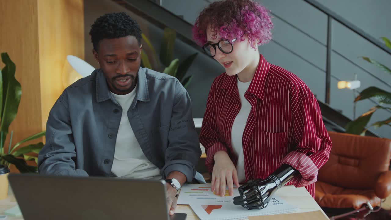 Businessman Having Talk with Female Colleague with Prosthetic Arm in Office