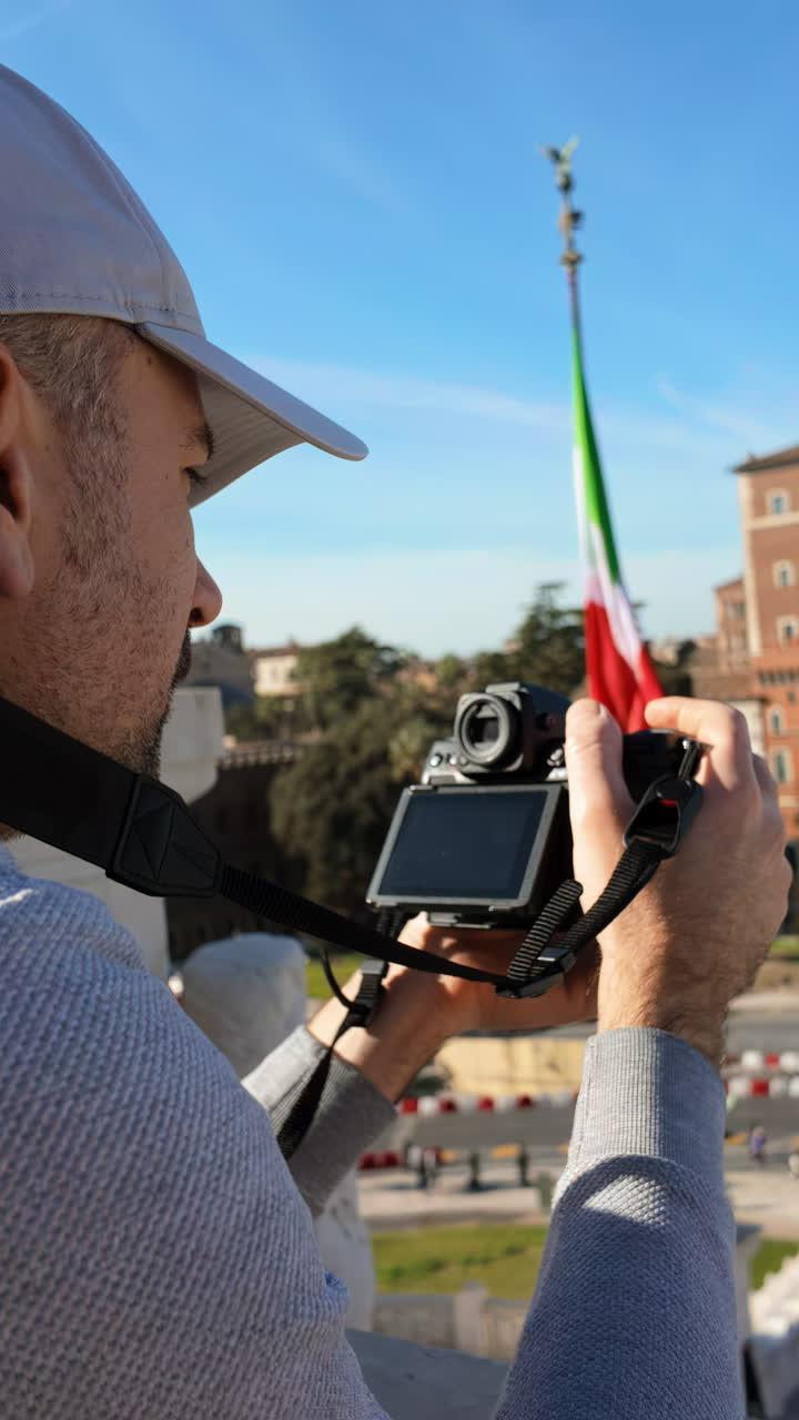 Uomo che filma le strade di Roma, Italia, da un punto elevato. Verticale