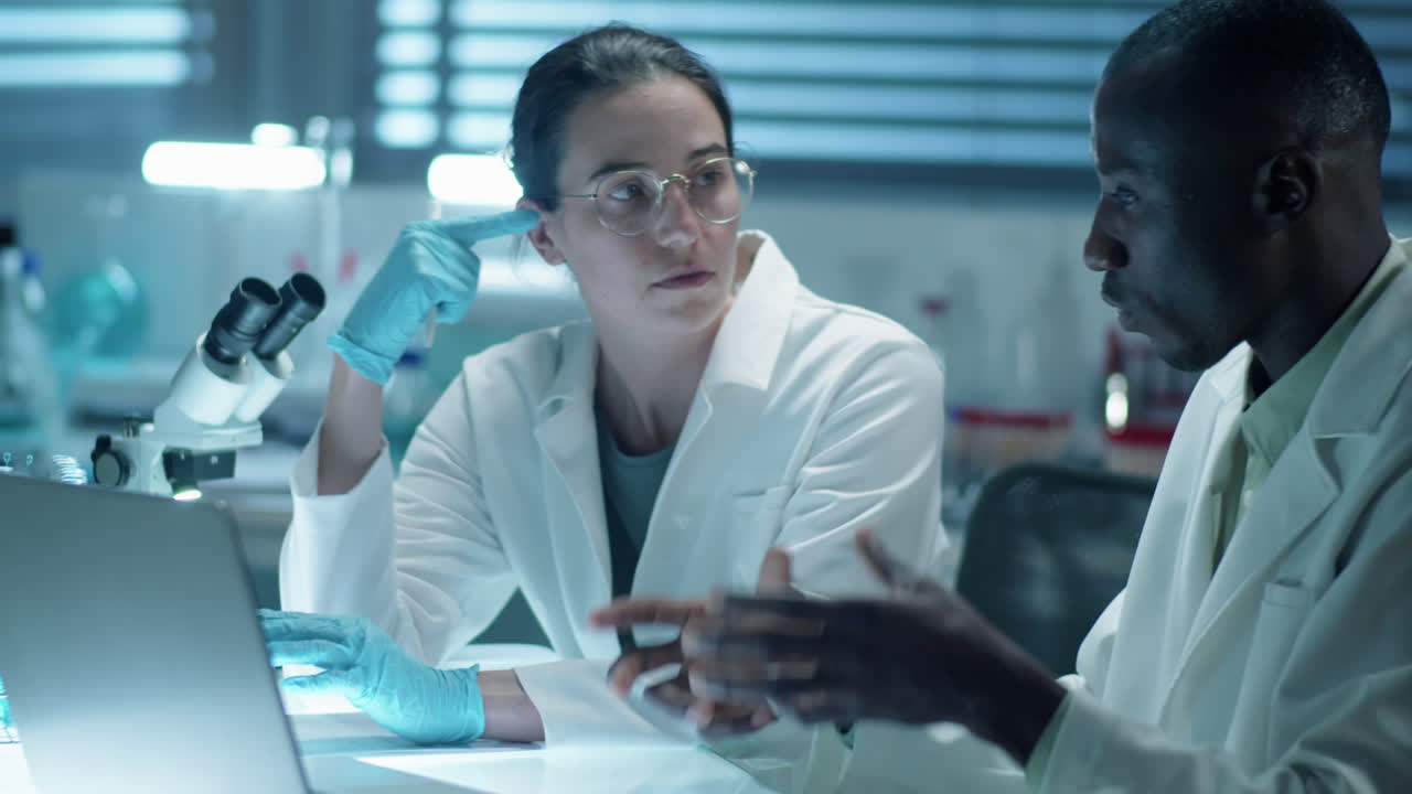 Diverse Scientists Working with Laptop in Laboratory