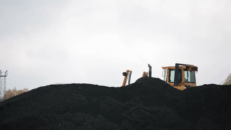 coal mining industry and transportation. yellow tractor riding at coal warehouse for transportation