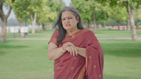 sick indian old woman suffering from arthritis in park