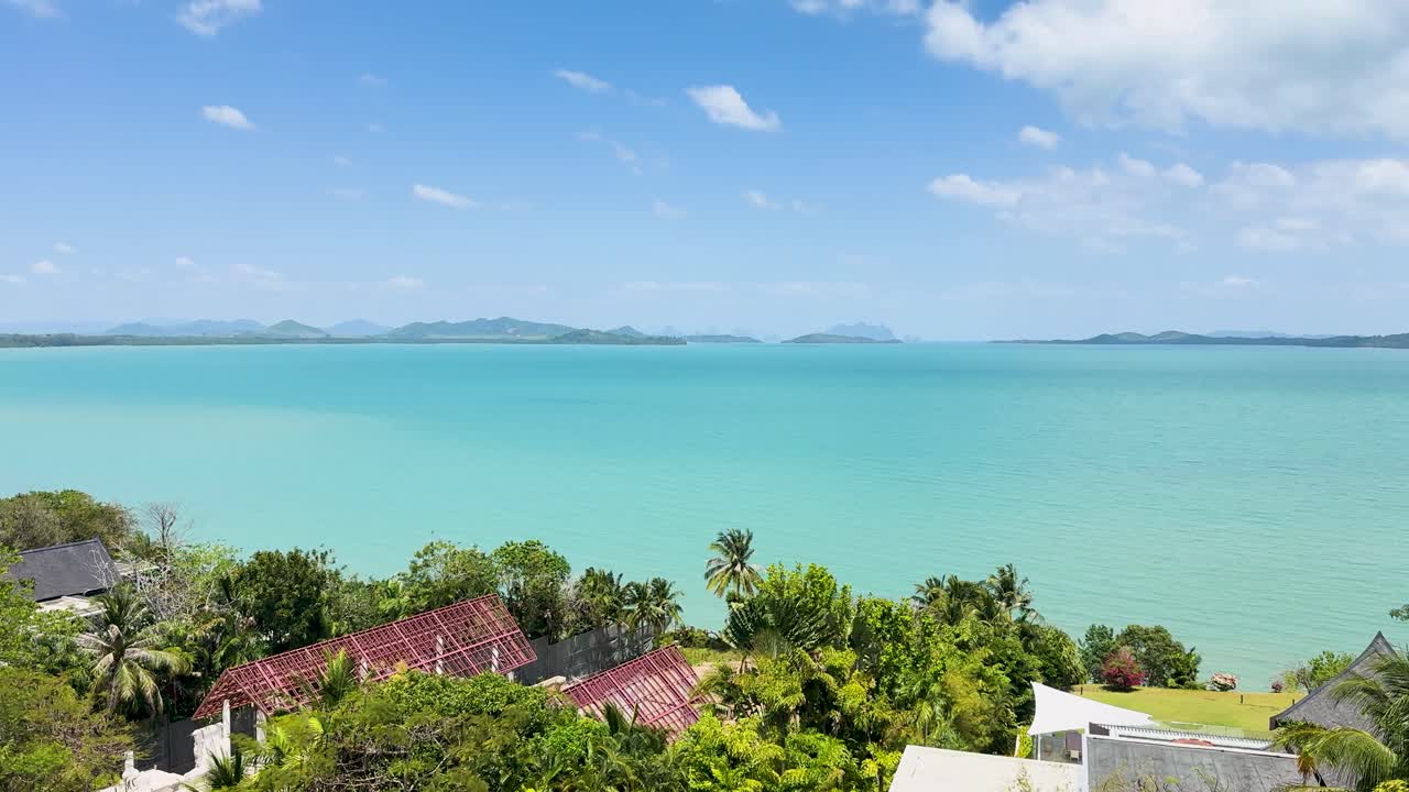 푸켓의 케이프 야무 (cape yamu) 의 조용한 공중 풍경, 은 파란 하늘 아래 푸른 물과 울창한 초록색을 보여줍니다.