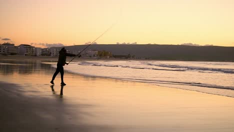 Pescador-Lanzando-Su-Bastón-Hacia-El-Mar-Al-Amanecer