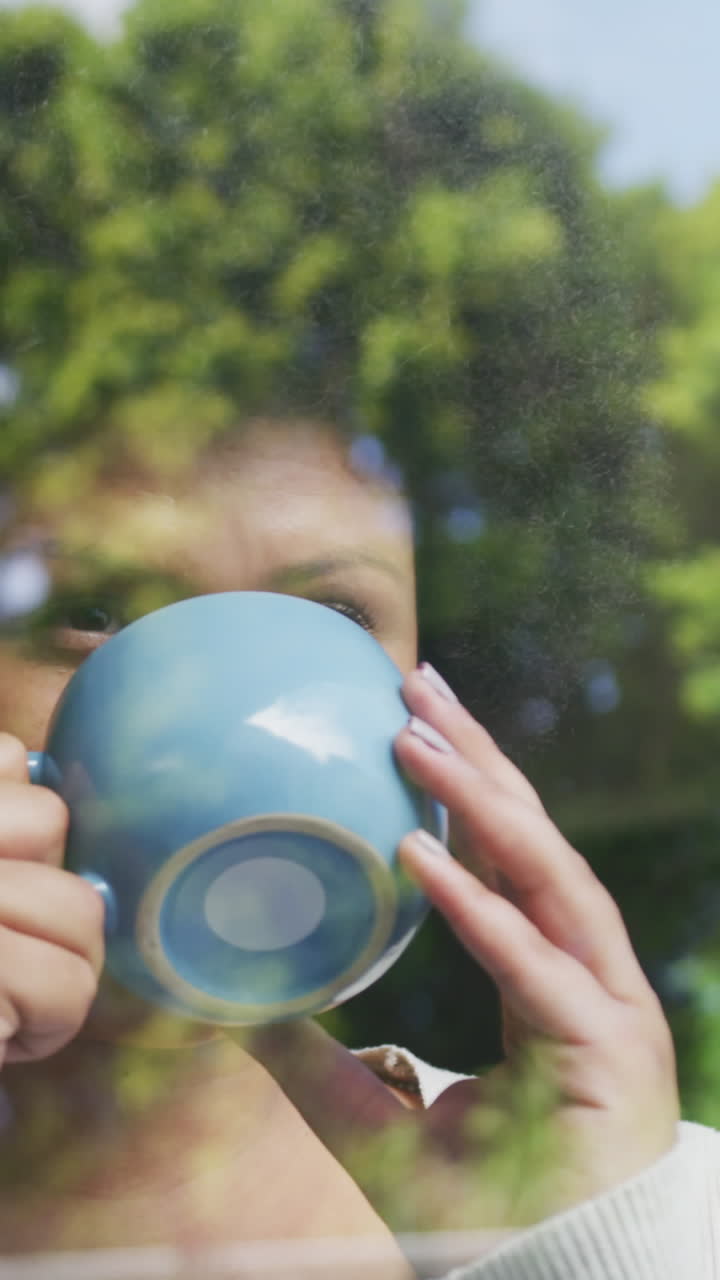 커피를 마시며 창밖을 바라보는 편안한 플러스 사이즈 아프리카계 미국인 여성의 비디오