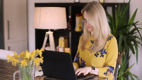 mujer trabajando en una computadora portátil en casa