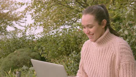 Mujer-Trabajando-En-Una-Laptop-En-Un-Parque-Celebrando-Un-Primer-Plano-Feliz