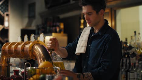 male bartender beer at bar to the clients