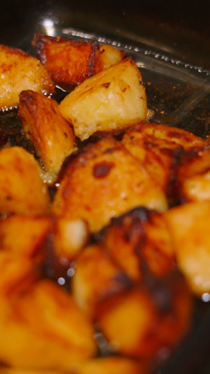 Vertical Video Moving from Roast Chicken in Tray with Bubbling Roasted Potatoes in Glass Dish. English Traditional Roast Dinner.