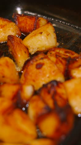 vertical video moving from roast chicken in tray with bubbling roasted potatoes in glass dish. english traditional roast dinner.