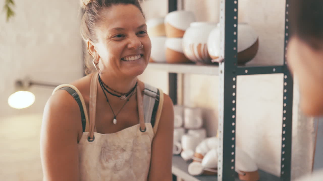 dos mujeres jóvenes amasando arcilla en un estudio de cerámica