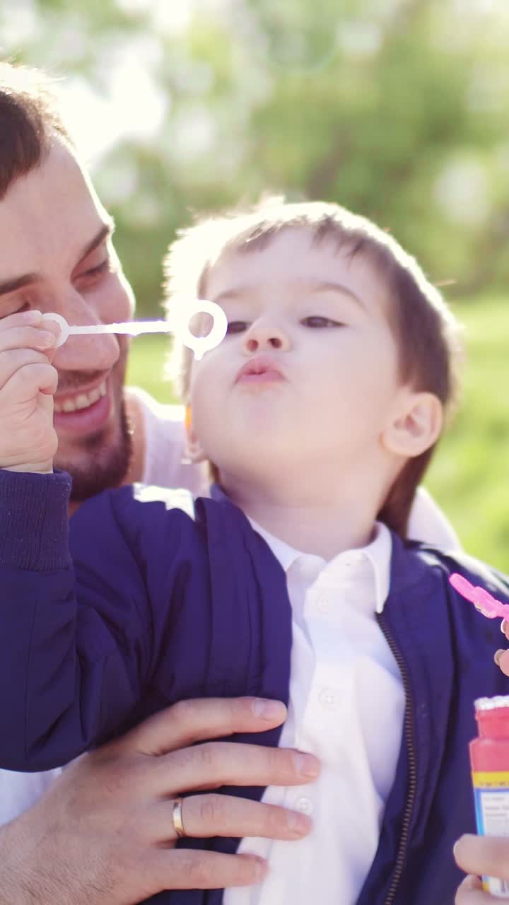 Father and Son Playing with Bubbles in a Park