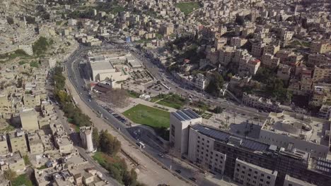 scenic aerial shot taken by a drone in the middle of a bright sunny morning in amman jordan showing the horizon and architecture built on the mountainous sides