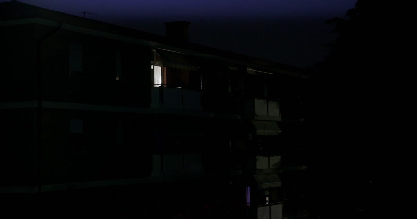 Exterior de edifício de apartamentos com relâmpago durante tempestade em noite escura em Bassano Del Grappa, Vêneto, Itália. Plano elevado