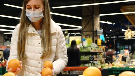 young woman buys oranges at the fruit market. ripe sweet fruits. natural vitamin c