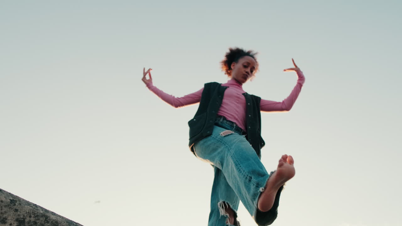 Young Woman Dances Barefoot on Rooftop at Sunset