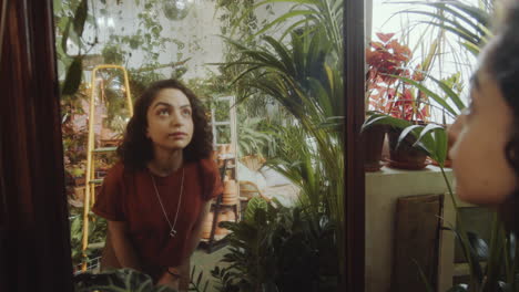 girl looking in mirror in plant filled room